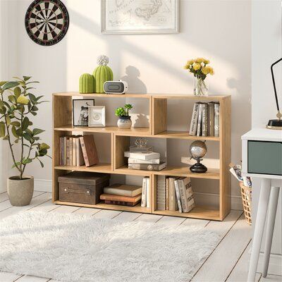 Display your favorite books or keepsakes with this geometric bookcase, which measures 33'' high and 55'' wide. Crafted from engineered wood, it features a clean-lined silhouette with a horizontal orientation that makes it ideal for doubling as a console table or TV stand. An oak finish is easy to pair with your colorful accents or modern details. Plus, its six square and rectangular shelves alternate to create an asymmetrical yet balanced feel. Our favorite detail? It's scratch-resistant, so it Open Cube, Open Bookshelves, Bookshelf Storage, Cube Bookcase, Storage Display, Bookcase Shelves, Display Storage, Oak Color, Menu Furniture