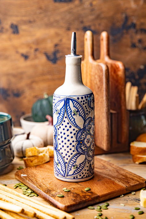 Our exclusive Tunis White & Blue Ceramic Oil Bottle features a unique medallion design inspired by the traditional Tunisian artwork found throughout Northern Africa and parts of Spain. Truly one of a kind, this hand-painted ceramic bottle includes a rubber gasket for airtight storage and a stainless steel spout for drip-free pouring. #WorldMarket Tunisian Ceramics, Cooking Oil Bottle, White And Blue Ceramic, Pantry Inspiration, Northern Africa, Olive Oil Bottle, Acorn Crafts, Gin Bottle, Kitchen Necessities