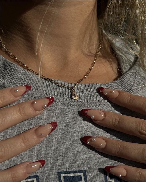 Red Almond Nails With Pearls, Red French Tip Nails Almond With Pearls, Pearl Nails With French Tip, Red Pearly Nails, Maroon Nails With Rhinestones, Red French Tip Nails With Diamonds, Red French Tips With Pearls, Red French Tips With Gems, Red French Tip With Pearls