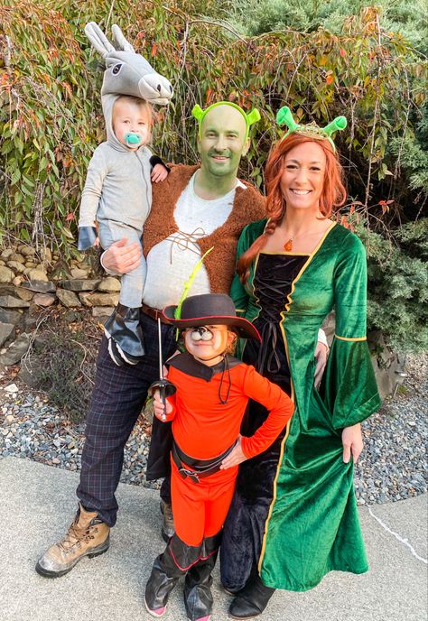 Family of 4 dressed as Shrek characters for Halloween. Donkey, shrek, Fiona, Puss N Boots Shark And Fiona, Unique Family Costume Ideas, Baby Shrek Costume, Family Shrek Halloween Costumes, Shrek Fiona And Donkey Costumes, 4 Family Halloween Costume, Shrek Family Costume Halloween, Fantasia Shrek E Fiona, Halloween Costumes For Family Of Four