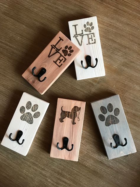 "Handcrafted dog leash hooks made of reclaimed pallet wood.  Each hook measures 7\" X 3.5\" and comes with wall mounting hook already attached.   Multiple patterns and colours available. Designs are burned on using pyrography (wood burning). Leash hooks start at $20 and can be personalized with a name or date.  Don't want one of the designs seen here? You can also have a hook made with a generic dog breed photo as well (see other listings in shop for examples).  $1 from each piece will be donated to a local animal shelter." Dog Craft Show Ideas, Dog Things To Make And Sell, Wood Projects For Pets, Pet Wood Projects, Dog Woodworking Projects, Dog Items To Make And Sell, Woodworking Gifts, Cute Wood Projects, Laser Gifts