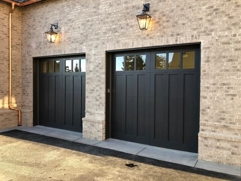 Classic Garage Doors, Garage Door Black, Tudor Garage Doors, Dark Garage Doors White House, Black Carriage Garage Doors, Carriage Garage Door, Black And White House Exterior With Wood Garage Door, Black Garage Doors Brick House, Transitional Garage Doors