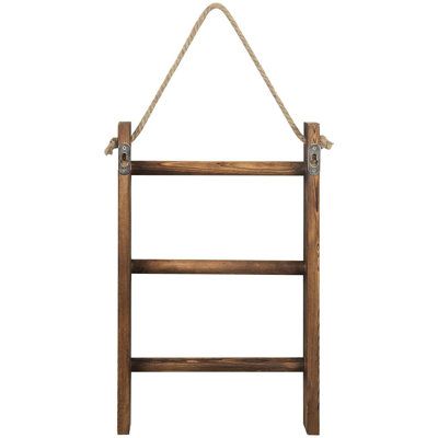 Add distinctive decoration and functional storage to your home with this wall-hanging wood towel ladder with rope. The 3-tiered design of this storage rack is perfect for displaying your finest towels, blankets, or decorative quilts. Easily mounted to most wall surfaces (Hardware not included), this towel storage ladder brings a touch of rustic decorative accent to any decor in your bathroom or bedroom. Finish: Dark Brown | Hingson Whitewashed & Wood Wall Hanging 3 Tier Hand Towel Ladder Rack, B Hand Towel Ladder, Wood Towel Rack, Storage Ladder, Hanging Ladder, Torch Wood, Bathroom Towel Storage, Towel Ladder, Rustic Wall Hangings, Towel Shelf