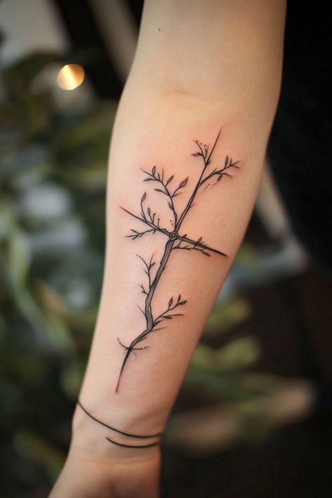 A forearm with a delicate tree branch tattoo, featuring thin lines and small leaves. Forearm Bible Verse Tattoos For Women, Cross And Tree Tattoo, Biblical Plant Tattoos, Biblical Nature Tattoos, Cross And Vine Tattoo, Cross With Olive Branch Tattoo, Christian Vine Tattoo, Unique Biblical Tattoos, I Am The Vine You Are The Branches Tatoo