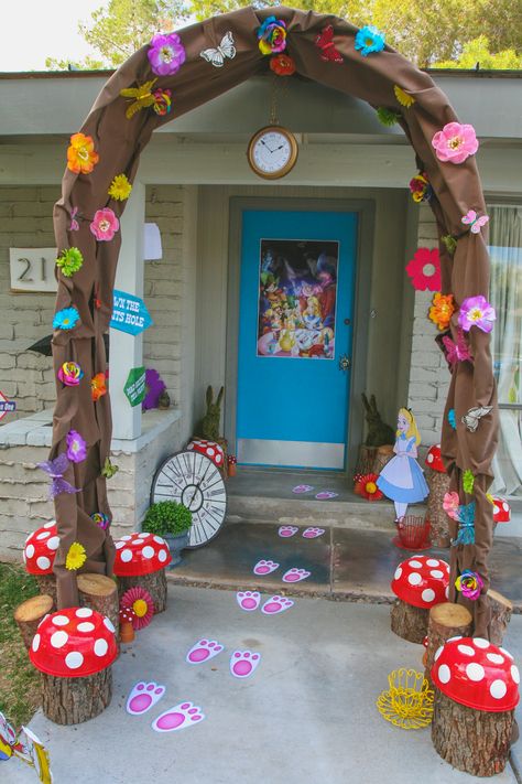 Down the Rabbit Hole and into Wonderland...  This was the entrance to my daughter's Alice in Wonderland themed party.  I re-purposed an old wedding arch and covered it in brown fabric, colorful flowers, and butterflies to create the rabbit hole.  Tree stumps from our backyard topped with "mushroom caps"  created larger than life toadstools.  You can even see the white rabbit left his footprints behind...Oh Mr. Rabbit!!! Alice In Wonderland Rabbit, Deco Disney, Alice In Wonderland Decorations, Alice In Wonderland Tea Party Birthday, Mad Hatter Party, Alice In Wonderland Birthday, Wedding Arch Flowers, Arch Decoration Wedding, Alice In Wonderland Theme