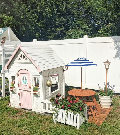 Outdoor Playhouse Setup, Garden With Playhouse, Outdoor Playhouse Toys, Kids Play House Landscaping, Diy Playhouse Decor, Playhouse Garden Ideas, Diy Outdoor Playhouse Makeover, Playhouse Outdoor Landscaping, Kids Playhouse Outdoors Diy