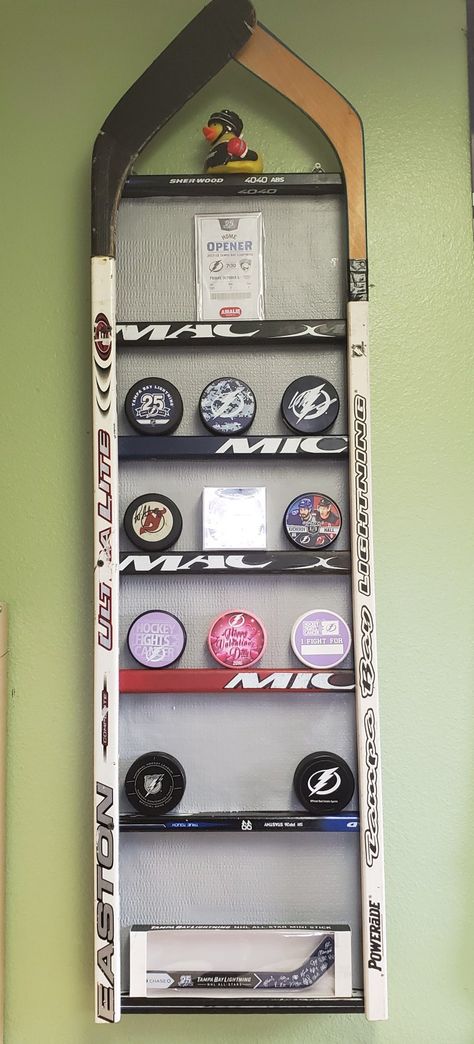 Hockey Stick Display Ideas, Christmas Hockey Decorations, Hockey Puck Shelf, Ice Hockey Themed Bedroom, Hockey Collage Ideas Pictures, How To Display Hockey Pucks, Hockey Stick Hat Rack, Hockey Shadow Box Ideas, Hockey Themed Basement