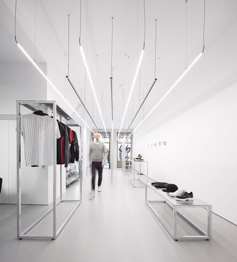 this streetwear store in porto portugal sets the stage for the minimalist clothing it offers. diogo aguiar studio designed the space with straight rigid lines in order to accentuate the store’s high ceilings and expansive length. one gets the impression of a much larger space. Clothing Store Design, Retail Lighting, Retail Interior Design, Interior Minimalista, Retail Store Design, Boutique Interior, Dark Interiors, Retail Interior, Store Design Interior