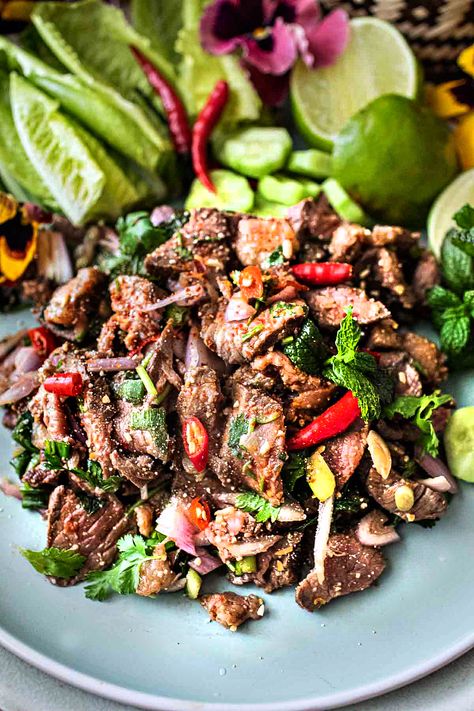 This authentic Thai beef larb recipe is a super tasty and popular dish from Isaan (Northeastern )Thailand. It's a flavorful salad made with near-raw, thinly sliced beef. This tasty Thai larb has a wonderful assortment of fresh herbs that bring out the bold, addictive flavors. It's an easy recipe, and it's extra healthy! #beeflarb #beeflaab #beeflarbrecipe #authenticbeeflarb #thailarb #thailaab #thailaabrecipe #authenticlaabrecipes Thai Food Salad, Spicy Beef Salad Thai, Thai Laab Recipe, Nam Tok Beef Salad Recipes, Thai Chicken Larb, Beef Larb Recipe Thai, Thai Recipes Beef, Thai Beef Marinade, Larb Recipe Thai Authentic