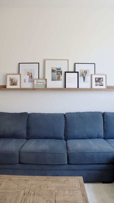 Shelf With Pictures, White Picture Ledge Above Couch, Picture Ledge Frame Sizes, 60 Inch Picture Ledge Layout, Photo Ledge Display Over Sofa, Behind Couch Picture Ledge, Bedroom Picture Ledge, Diy Picture Frame Shelf, Frame Arrangement On Shelf