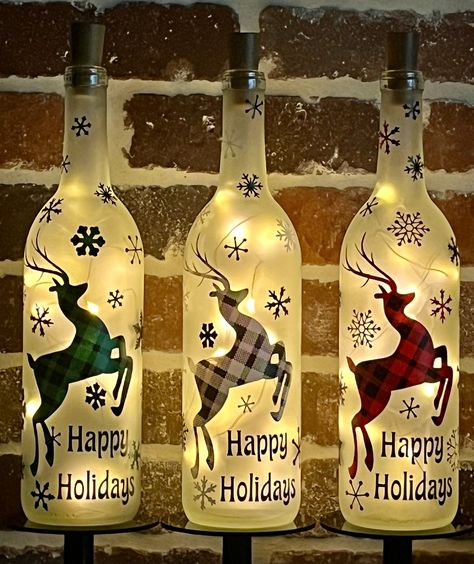 This frosted bottle features a prancing reindeer surrounded by snowflakes and the Happy Holidays message.  I use an assortment of snowflake styles and sizes in coordinating colors.  Snowflakes are placed randomly, as the size, color or placement of each one dictates the next one, and so on.  And I think it's more fun that way!  The plaid pattern is classic and elegant, but the snowflakes keep it whimsical and fun.  I just love this design - so much so that I wanted to offer it in three colors! T Christmas Wine Bottle Crafts, Holiday Wine Bottle Crafts, Wine Bottle Christmas Decorations, Cork Light, Beer Bottle Art, Alcohol Bottle Crafts, Christmas Winter Decor, Glitter Ideas, Wine Bottle Cork