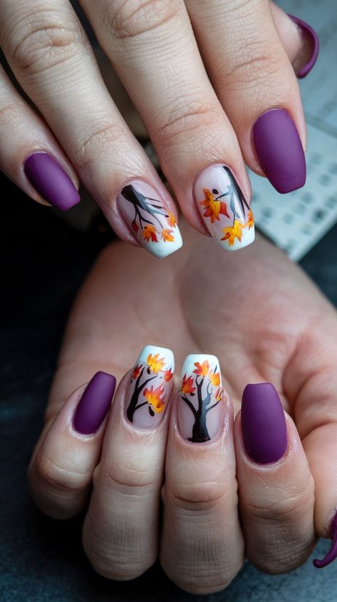 Embrace the beauty of fall with these stunning nail designs! Featuring a rich purple matte finish paired with delicate autumn leaves and trees, these nails capture the essence of the season. Perfect for cozy sweater weather or a chic night out. Get inspired to bring the colors of autumn to your manicure! #septembernails #fallnails Purple And Gold Fall Nails, Thanksgiving Nails Purple, Autumn Purple Nails, Purple Thanksgiving Nails, Fall Tree Nail Designs, Autumn Nails Purple, Purple And Orange Nail Designs, Purple Fall Nails Design, Cute Purple Nail Ideas