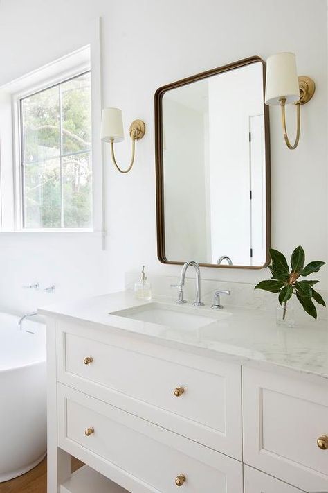 White Vanities With Gold Hardware, Satin Nickel And Brass Bathroom, Black And Brass Hardware Bathroom, Antique Brass Bathroom Sconces, Chrome And Antique Brass Bathroom, Light Blue And Brass Bathroom, Beige Sink Bathroom Ideas, Chrome And Brushed Brass Bathroom, Curved Bathroom Backsplash