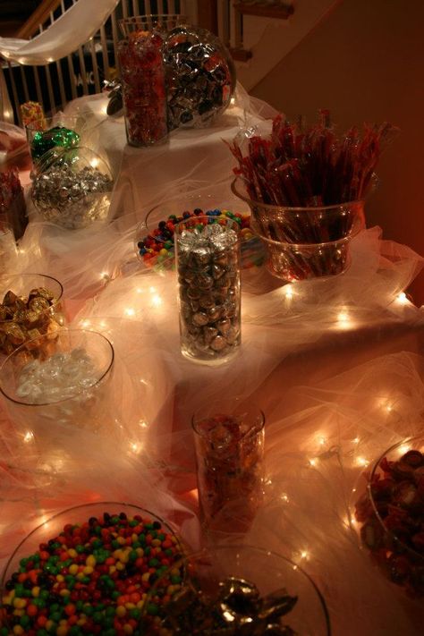 Utiliza tul y extensiones de luces blancas para darle un efecto único a tu mesa dulce o buffet de dulces. #MesasDulces Candy Table Ideas Wedding Dessert Buffet, Fancy Candy Bar, Candy Bar Round Table, Candy Table Centerpieces, Holiday Candy Bar Buffet, Candy Buffet Signs, Food Display Table, Candy Display, Party Buffet