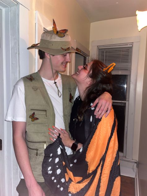 A couple wearing a butterfly costume and a bug catcher costume. Bug catcher is wearing a beige vest with a safari hot with butterflies pinned on. The butterfly is wearing a black dress with black tights and a pair of monarch wings Ladybug And Bug Catcher Costume, Butterfly Catcher And Butterfly Costume, Hollow Web Costume Ideas, Couples Butterfly Costume, Bug And Bug Catcher Costume, Bee And Bee Keeper Costume Couple, Zoo Keeper Couple Costume, Butterfly And Bug Catcher Costume, Bee Catcher Costume