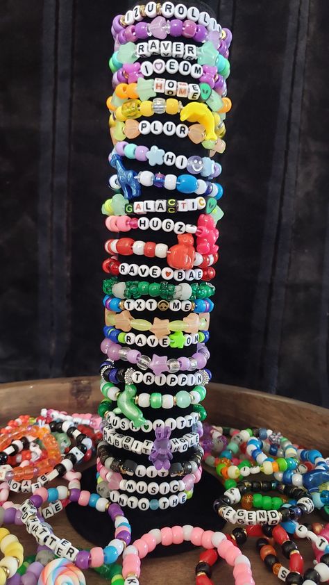 These bracelets are great for parties, raves, EDM, concerts, and music festivals. Don't forget your Kandi before your next event. These are great to trade with your friends and family.  **These are pre-made kandi bracelets & will be picked at random. *Pictures are examples of the colors/words. *I use commonly requested words/phrases.   *Handmade in a smoke free environment. Kandi For Beginners, Kandi Inspo Single, Rave Bracelets Ideas, Rave Candy Bracelets Ideas, Kandi Phrases, Kandi Words Ideas, Kandi Singles Ideas, Emo Kandi, Kandi Charms