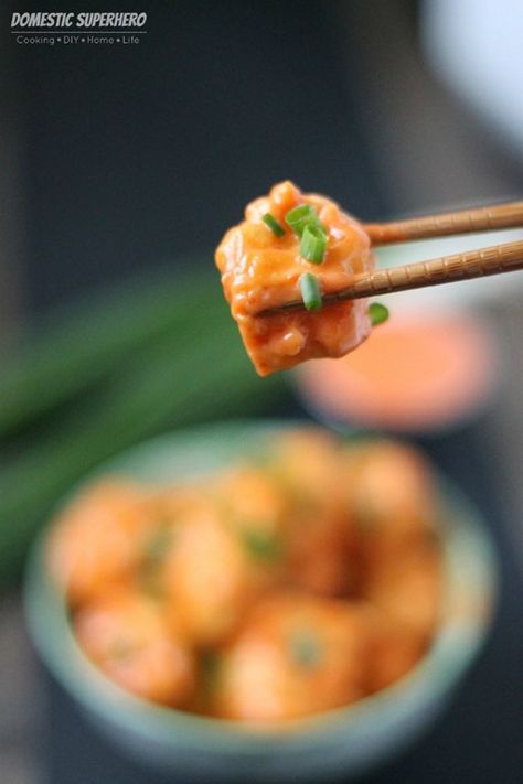 the chopsticks are holding up some food that is on top of another bowl