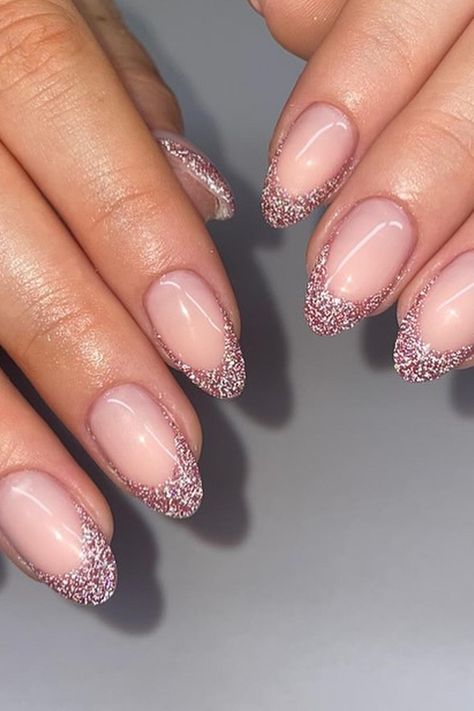 Almond-shaped nails with a sheer pink base exude elegance. The tips are dipped in fine silver glitter, creating a sophisticated French manicure with a sparkling twist. This timeless yet trendy style adds a touch of glamour to any look. Simply chic! ✨  // Photo Credit: Instagram @angelsbyannabel French Manicure Designs With Glitter, Glitter Nail French, Almond Shape Glitter French Tip, Almond Nail Inspo Glitter, Sparkling French Manicure, Almond Nails French Tip With Glitter, Light Pink New Years Nails, Pink Sparkly French Tip Nails Almond, Sparkle Pink French Tip Nails