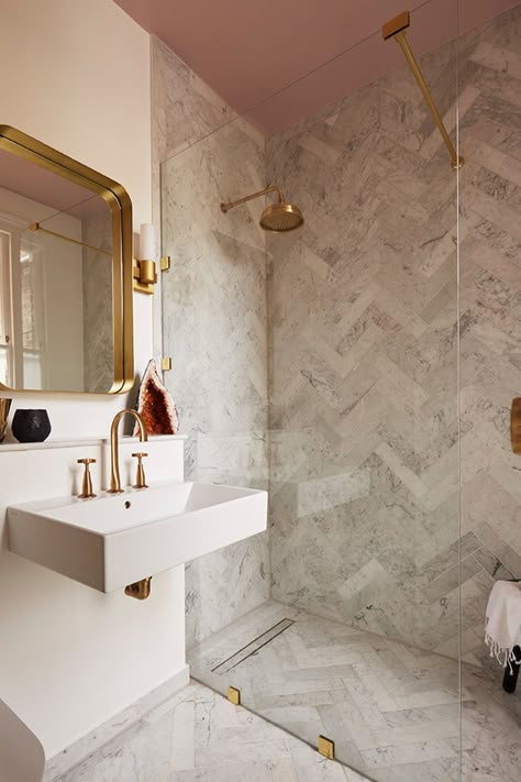 There's something super flattering about painted ceilings - why not give that fifth wall a little love?🌸This pink ceiling matched with these brass assets and marble-effect herringbone tiles creates a modern, minimalist bathroom design that we love!  📸: Victoria Tunstall Herringbone Tile Bathroom, Chevron Flooring, Chevron Bathroom, Mandarin Stone, Minimalist Bathroom Design, Loft Bathroom, Perfect Bathroom, Small Bathroom Makeover, Marble Wallpaper