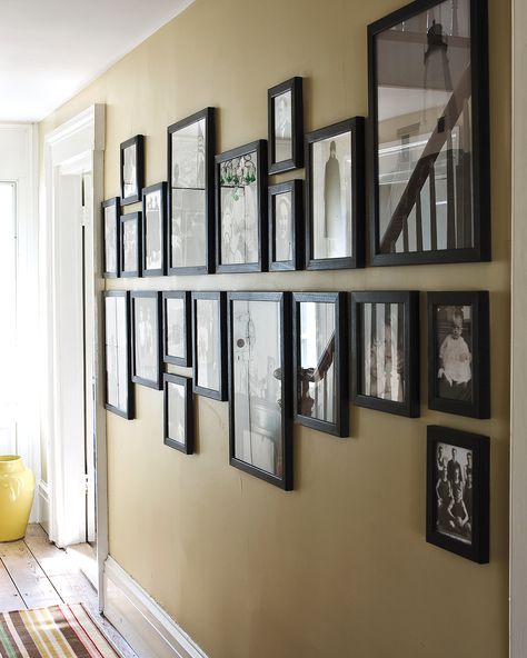 12 Brilliant Ways to Decorate a Blank Wall | A blank wall is like a blank canvas—it's filled with possibilities. What better way to make use of the walls in your home than to celebrate the loved ones who fill it? In this setting, a set of family photographs are unified with identical black frames. The arrangement trick also further elongates the length of the wall.  #homedecor #wallart #marthastewart #diydecor Hallway Pictures, Photo Wall Display, Family Photo Wall, Diy Wand, Hal Decor, Small Hallways, Wall Frames, Boho Interior, Wall Gallery