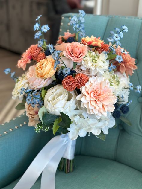 Stunning Bridal bouquet in terra-cotta, off-white, Dusty blue and blush. This bouquet is made with high quality silk flowers consisting of peonies, roses, hydrangeas and eucalyptus leaves. It has all the elegance, beauty and romance you could want and the wow factor you are looking for. Each floral arrangement is handmade with great attention to detail and fine craftsmanship. Bouquets are finished with ribbon color of your choice. You can be sure to love the product you receive and it will last and be beautiful for years to come! *Pictures show 13-14" bride bouquet * This bouquet can be customized to your liking and needs. If you would like a different color palette, different accent or different type of flowers I am very accommodating. I love to work with brides to make you exactly what y Dreamy Flowers Aesthetic, Sage And Blush Wedding Bouquet, Dahlia And Eucalyptus Bouquet, Different Flower Bouquets, Fall Dusty Blue Wedding, Wild Flower Bridesmaid Bouquet, Dusty Blue Flower Arrangements, Bouquet For Blue Dress, Navy Coral Wedding