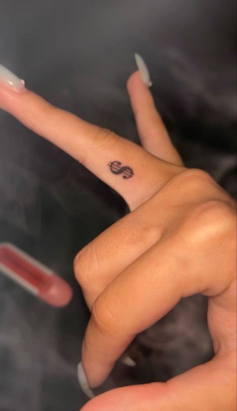 Dollar tattoo,tattoo,finger tattoo Hand Tats Small, Dollar Sign Tattoo On Finger, Tiny Tattoos Design, Money Sight Tattoo, Money Sign Tattoo On Finger, Dollar Sign Finger Tattoo, Coin Size Tattoo, Arabic Tattoo With Butterfly, Red Dollar Sign Tattoo