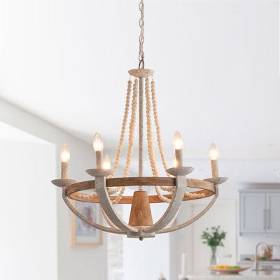 This 6-light wagon wheel chandelier has a pared-down, open frame that makes it casual enough for your rustic dining room table. This fixture is crafted from metal with a grey/antique white finish, and it strikes an empire silhouette with beaded accents for a boho touch and hangs from an adjustable chain. With its open design, this chandelier provides ample illumination to brighten up any room. It creates a warm and inviting atmosphere for the dining room, laundry room, bedroom, hallway, or entry Industrial Style Living Room, Rustic Dining Room Table, Wood Bead Chandelier, Beaded Candle, Empire Chandelier, Rustic Dining Room, Wagon Wheel Chandelier, Iron Lamp, White Pendant Light