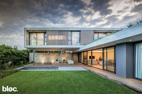 Orientated around a defined courtyard, this house is designed to maximised indoor/outdoor living. A large landscaped roof creates garden access to the bedroom on the first floor. The solar panels on the roof are one of many green strategies employed to reduce the impact on the environment. Bungalow Landscaping, U Shaped House Plans, L Shaped House Plans, U Shaped Houses, Double Storey House Plans, L Shaped House, Architecture Contemporary, Double Storey House, Interior Architects