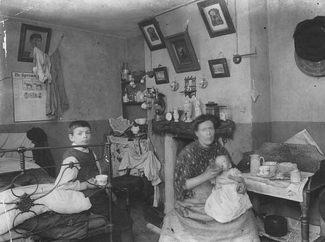 East End Home December 1912: A mother and baby and a child sit in a typical London 'slum' family home. Their room serves as a kitchen and a bedroom. (Photo by Topical Press Agency/Getty Images) Historical London, Victorian London, London History, Bethnal Green, Old London, London Photos, Vintage London, British History, A Typical