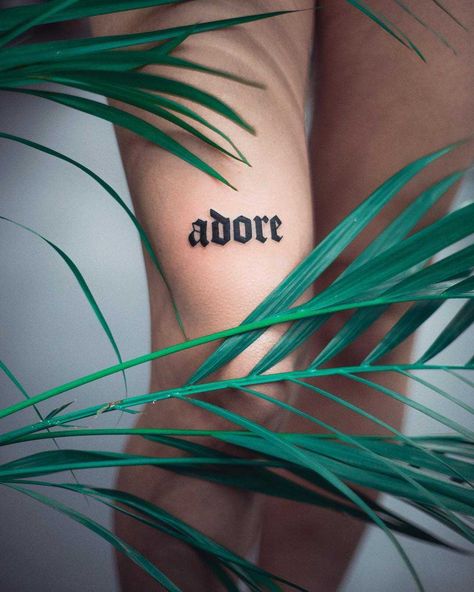 Word ‘adore’ inked on the right thigh by tattooist Dżudi Bazgrole Thick Tattoo Fonts, Bold Script Tattoo, Bicep Word Tattoo Women, Big Letter Tattoo, Word Tattoo Thigh, Adore Tattoo Word, Big Word Tattoos, Traditional Script Tattoo, Bold Tattoo Fonts