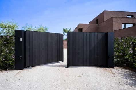 This beautiful black swinging gate offers a stylish and secure entrance to the sleek modern villa, where black accents are prominent. This connection ensures a seamless integration between the gate and the house, harmonizing them beautifully. Both elements also blend effortlessly into the green surroundings, radiating natural elegance.

Architect: Julie Thiers Contractor: Livinlodge Photographer: Sten Van Slycke Black Gates Entrance, Car Gates Entrance, Modern House Front Gate, House Front Gate, Backyard Vibes, Contemporary Gates, Black Cladding, Black Gate, Modern Gate