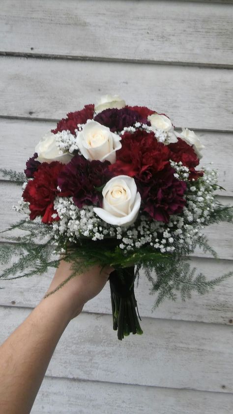 Rich colored bridal bouquet of burgundy and deep purple carnations, cream roses and baby's breath Maroon And White Flower Bouquet, Wine And White Wedding Bouquet, Sept Wedding Flowers, Original Flower Bouquet, Colorful Mini Bouquet, Wine Red Flower Bouquets, Burgundy Carnation Bouquet, Burgundy And White Bridal Bouquet, Burgundy Bride Bouquet