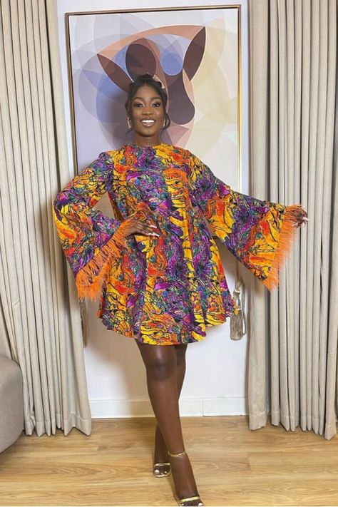 A lady wearing an Ankara fur gown Short Ankara Flare Gown Styles, Fled Gown Ankara, Lastest Style For Materials Short Gown, Flare Ankara Gown Styles, Ankara Short Gown Styles 2023, Ankara Flare Dresses, Flare Gown Ankara, Ankara Short Gown Styles 3yards, Short Flare Gown Styles