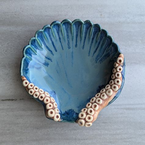 This handmade ceramic dish will add a unique touch to any room. The shell displays a variety of blues while the tentacles are a fleshy pink color. I also offer tentacle mugs, ring dishes, and trays so check out the other listings to own the complete set! Dimensions:  Large-8.25" x 6.75" x 1.25" Medium-4" x 4" x 1.25" *For new products and to get a behind-the-scenes view of a ceramic artist, check out my Instagram @27SistersStudio *All of my pottery is fired with ceramic glazes so the colors will Octopus Clay Art, Star Wars Ceramics, Clay Beach Ideas, Under The Sea Ceramics, Sea Ceramics Ideas, Creative Ceramics Ideas, Beach Ceramics, Ocean Ceramics, Shell Displays