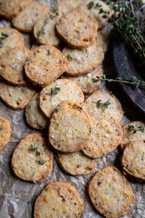 Savory shortbread cookies on crumbled parchment paper, topped with fresh thyme. Pink Peppercorn Cookies, Savoury Shortbread Cookies, Savoury Cookies Recipes, Savory Christmas Cookies, Savory Christmas Gifts, Savory Holiday Snacks, Savory Christmas Snacks Gifts, Savory Holiday Treats, Savory Cookies Recipes