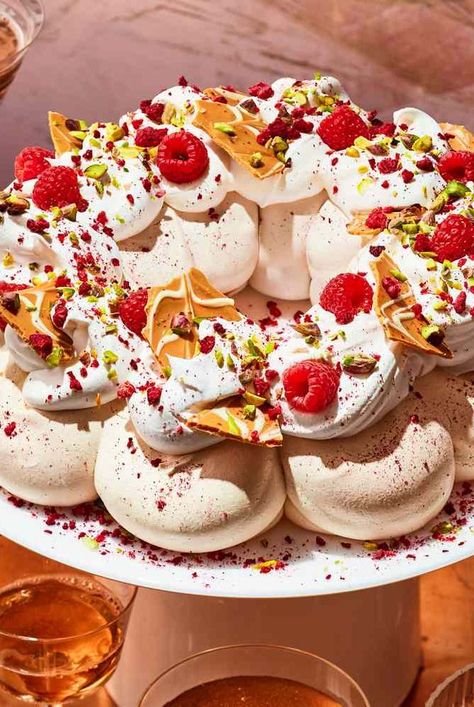 This stunning Pavlova with Caramelized White Chocolate Bark from cookbook author Kristina Cho is shaped like a wreath and topped with crumbled freeze-dried red raspberries and bright green chopped pistachios for a festive holiday dessert presentation. Raspberry Pistachio Wreath, Amazing Christmas Desserts, Pavlova Wreath, Boiled Fruit Cake, Chocolate Peppermint Brownies, Chocolate Pavlova, Lemon Curd Cake, Caramelized White Chocolate, Caramel Pears