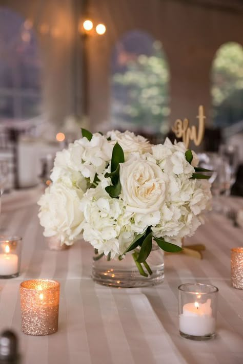 Low White Rose Centerpiece, One Vase Wedding Centerpiece, Small Centerpieces With Candles, White Rose Bouquet Centerpiece, White Roses In Glass Vase, Wedding White Roses Centerpiece, Simple Hydrangea Centerpiece Wedding, Bridal Bouquet As Table Centerpiece, Clear Vases With Flowers