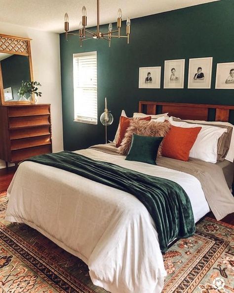 a mid century modern bedroom with a dark green accent wall, a stained bed and dresser, a gilded chandelier, bright bedding and a mirror in a gilded frame Emerald Green Bedrooms, Dresser Bedroom, Green Accent Walls, Decor Mirror, Bedroom Orange, Dekorasi Kamar Tidur, Green Bedroom, Green Walls, Bedroom Dresser