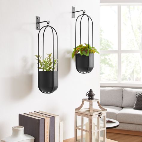 Summer home decor just got better with these stunning wall planters! Meet the Walter 2-Piece Modern Black Metal Oval Hanging Planter Set. Say goodbye to bare and boring walls, and hello to these modern planters. Hang them in your living room, bedroom, kitchen, or garden to add some greenery! #danyabhome #homedecor #interiordesign #homestyle #interiorinspo #wallplanters #modernhomedecor #modernminimalism Metal Hanging Planters, Hanging Frames, Hanging Planter, Wall Planter, Oval Frame, Hanging Planters, Outdoor Shade, Black Metal, Modern Design