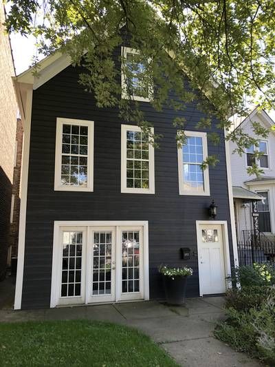 Dark Brown Ranch House Exterior, Dark Grey Cottage Exterior, Dark Cape Cod House Exterior, Dark Exterior Brick House, Black House Siding, Dark Painted Houses, Black House Green Door, Charcoal Siding House, Charcoal Grey House Exterior