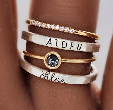 The Athena Ring Set offers a timeless combination of classic elegance and fine craftsmanship. Crafted from pure silver and 14K yellow gold filled, the set includes a 4mm gray cz stone and a custom-made name ring in both uppercase skinny font and lowercase cursive. It also includes our new cz stone ring with 10 tiny sparkles. Get a timeless look with this exquisite and beautiful set. We highly recommend ordering our ring sizer before purchase to ensure a good fit. Some people need to size up half Rings Mixed Metals, Names Jewelry, Stackable Name Rings, Birthstone Stacking Rings, Mothers Ring, Mixed Metal Rings, Push Presents, Handwriting Jewelry, Mother Rings