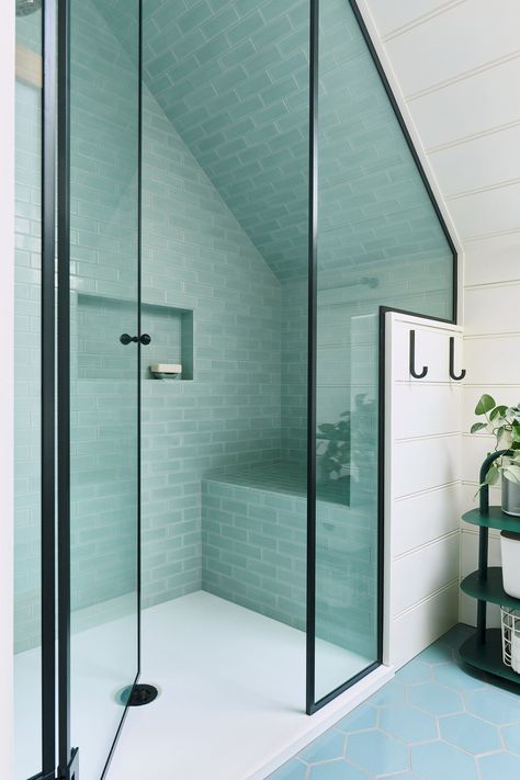 The 2nd floor bath has a roomy shower tiled in ocean hues with a smart under-eave shower bench. Loft Wetroom Ideas, Angled Ceiling Bathroom Vanity, Bathroom Ideas Loft, Slanted Shower Ceiling, Small Bathroom Slanted Ceiling, A Frame Bathroom, Eaves Bathroom, Attic Ensuite, Loft Bathrooms