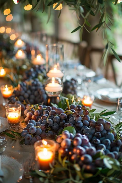 ✨ Elevate your wedding ambiance with a centerpiece that whisks you away to the rolling hills of Tuscany. Experience the charm of Italy as grape vines & olive branches intertwine with the warm glow of candles on your special day. #WeddingInspiration #TuscanWedding #RomanticDecor #WeddingIdeas #CountryChic #RusticElegance #GrapeAndOlive #CandlelightMagic Let the light guide your love story. Italian Inspired Centerpieces, Vine Table Decor, Wine Dinner Centerpieces, Grapes Centerpiece Wedding, Grape Centerpiece Wedding, Tuscany Wedding Table Decor, Italian Centerpieces Table Decorations Tuscan Style, Grape Wedding Decor, Grape Centerpiece Ideas