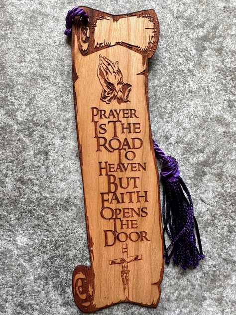 "Beautiful Christian bookmark made from a solid piece of cherry wood. The bookmark features an engraving of Jesus on the cross and a pair of hands praying, along with the phrase \"Prayer Is the Road to Heaven but Faith Opens the Door\" on a scroll shaped bookmark. Laser engraved to give it a beautiful 2D feel to it.  The bookmark can additionally be personalized on the back with either a name or message for a small additional cost. It measures approximately 6\"T x 2\"W and is 1/16\" thick (about Wood Burning Cross Designs, Christian Bookmark Ideas, Wood Crosses Diy, Hands Praying, Wooden Cross Crafts, Diy Laser Engraver, Cross Bookmark, Jesus Wall Art, Bible Bookmark