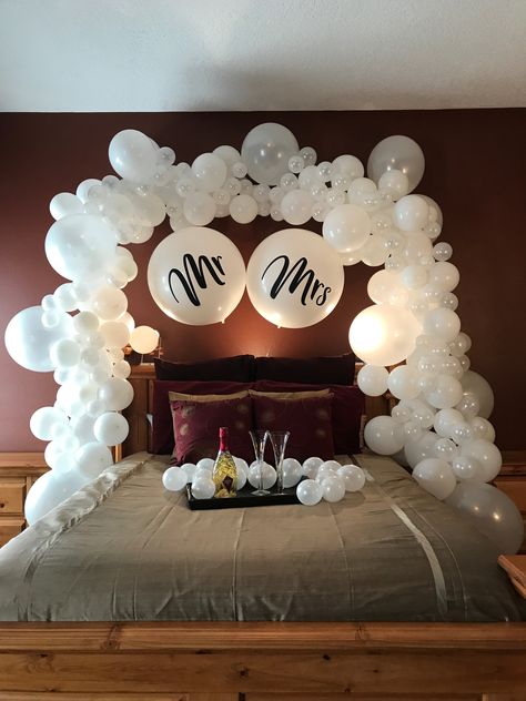 His and hers wedding balloon decorations are gorgeous even after the reception! Use creative balloon arch decorations for something unique, like your honeymoon bed. Complete with mini balloons with no helium for extra pop! Date Night Balloon Decor, Wedding Day Bedroom Decor, Wedding Bed Decor, Wedding Bedroom Ideas, Hotel Room Honeymoon Decor, Bed Decorating Ideas For Wedding, Balloon Decorations Hotel Room, Wedding Room Decor Ideas, Engagement Bedroom Decorations