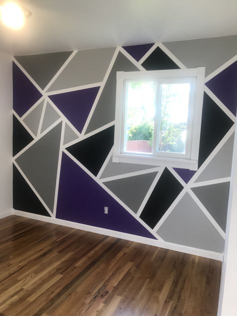 When your son says he would like to use hot rod purple and black for colors in his room...you become resourceful! Made this geometric accent wall with painting tape. Added two shades of grey to the mix. Found this idea on Pinterest!!🖤💜🖤💜🖤 If you paint the tape edges first the same color as your background, your lines will be perfect. Instead of “bleeding” the main color they “bleed” invisible. Do not let dry long, just enough so you can paint your main colors. Tape comes off easy then. Tape And Paint Walls, Purple And Black Geometric Wall, Purple Bedroom Paint Ideas, Blue And Purple Wall Paint Ideas, Purple Wall Design Paint, Purple And Grey Room Ideas, Geometric Wall Paint Purple, Tape Painting Wall, Purple Wall Painting Ideas Bedroom