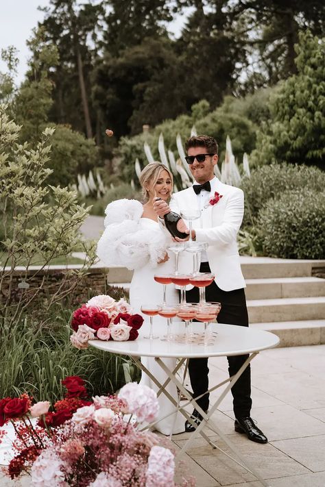 Red and pink wedding theme at Middleton Lodge. The bride wears a Chosen by Kyha dress with puff sleeves adorned with pearls and Chanel shoes. Pink And Red Wedding Groomsmen, Light Pink And Red Wedding, Cherry Wedding Theme, Red Pink And Black Wedding, Pink Red Wedding Theme, Pink And Red Bridesmaid Dresses, Cherry Red Wedding, Wedding Bouquet With Pearls, Pink And Red Wedding Theme