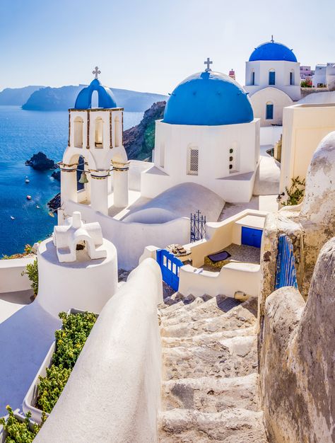 Mediterranean sunshine beams down on a honeycomb of whitewashed homes, hotels, cafes, and long stairways that wind down to the deep blue sea.  Roughly 3,500 years ago one of the Earth's largest volcanic events took a bite out of the island now known as Santorini (or officially: Thira). Built on the northern edge of the island's caldera, Oia is wedged into rock crevices and perched atop rugged cliffs overlooking the southern Aegean Sea. Grecia Santorini, Kusadasi, Oia Santorini, Santorini Island, Dream Travel Destinations, Beautiful Villages, Santorini Greece, Vacation Places, Beautiful Places To Travel