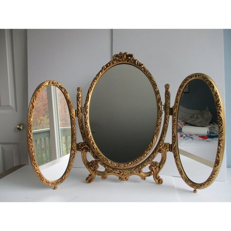 An Italian made, French Louis XVI style folding triptych table or vanity mirror.  This piece is made of metal and resin (plastic).  It features two folding oval side mirrors and a central mirror that can swivel upward or be completely removed from the mount; see pictures.  A fun and versatile mirror sure to please the eye.  This triptych mirror is in good vintage condition with some minor wear to the gilt paint on the body of the piece and a few minor specks on the mirrors themselves.  Please se Triptych Mirror Vanity, Heart Mirror Vanity, Vanity Mirror Vintage, 2 Vanities Side By Side, Vintage Gold Wall Decor, French Chic Home Decor, Vanity With Gold Mirror, Mirror Shapes Design, Gold Room Aesthetic