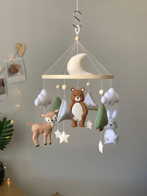 Woodland baby mobile for a nursery decor. This mobile with forest animals. The mobile includes: bear, deer, hare, mountains, trees, clouds, stars and the moon. The mobile is made in natural colors, which will make the interior of the room even more comfortable.  Mobile is a wonderful element of children's room decor, as well as an irreplaceable helper for the baby and parents. Mobile helps your child to improve their visual capability, development of intelligence and reflexes; entertains the bab Deer Themed Nursery, Forest Baby Rooms, Wilderness Nursery, Woodland Baby Nursery, Felt Baby Mobile, Baby Room Themes, Forest Baby, Nursery Room Design, Forest Nursery